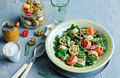 Colourful wheel-shaped pasta with broccoli leaves and garlic