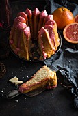 Vegan ring-shaped grapefruit Bundt cake with white rice milk chocolate and a slice cut out