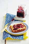 Red grape jam with cinnamon and star anise on bread and in a jar