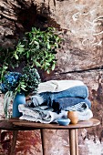 Folded blankets in shades of blue on a wooden table with flowers