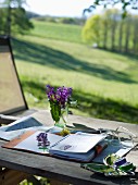 Flowers pressed in notebook on table with view across landscape