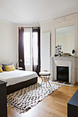 Open fireplace and stucco ceiling in black and white bedroom