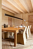 Dining table and loose-covered chairs in sand-coloured dining room