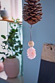 Bauble made from pine cone, wooden bead and paper rosette
