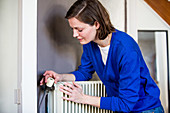 Woman adjusting a thermostatic radiator valve