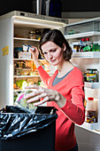 Woman throwing food in the trash