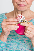 Woman putting money in purse