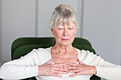 Senior woman practicing respiratory exercises