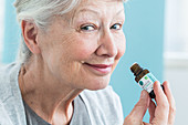 Woman smelling a bottle of essential oil