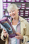 Woman choosing a knee support in a pharmacy