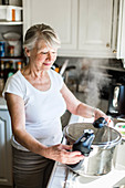 Senior woman using a pressure cooker