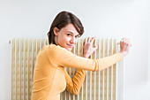 Woman adjusting a thermostatic radiator valve