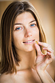 Woman taking food supplement capsule