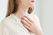 Woman self-examining her throat