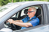 Senior driving his car