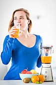 Woman making fruit juice in blender