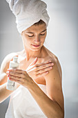 Woman applying cream on her arm