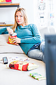 Woman snacking while watching TV