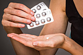 Woman taking statin cholesterol-lowering pills