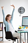 Office woman stretching arms at work