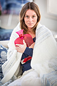 Woman holding a hot-water bottle