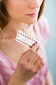 Woman holding oral contraception pills