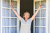 Woman stretching arms by the window