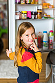 Child in front of a fridge