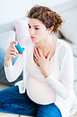 Pregnant woman using an asthma inhaler