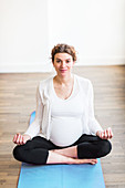Pregnant woman meditating in a yoga pose