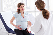 Doctor checking analysis results of pregnant woman