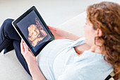 Woman looking at baby scan on a digital tablet