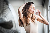 Young woman in front of electric fan
