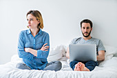 Couple with laptop computer arguing