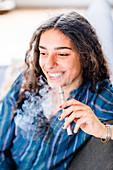 Teenage girl using electronic cigarette