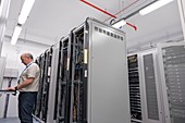 Technician checking servers in data centre