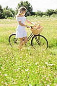 Woman in meadow with bicycle