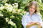 Woman by tree scratching arm