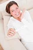 Woman holding positive pregnancy test