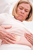 Woman applying hormone patch to tummy