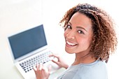 Mid adult woman using laptop