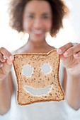 Woman holding bread with smiley face