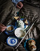 Coffee, muesli, a cheese dip and chocolate crispbread on a breakfast tray