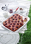 Almond and plum cake from the tray on an outdoor table