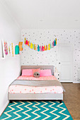 Tassel garland over the bed against a dotted wall