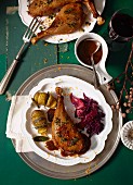 Goose leg in a baked plum and spiced sauce with red cabbage and hasselback potatoes