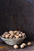 Walnuts in a basket against a rustic metal wall