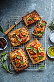 Feta cheese, olive, tomato shortcrust pastry tarts with sesame seeds and fresh basil