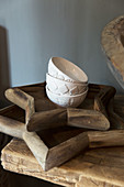 White bowls with relief patterns on two star-shaped wooden trays