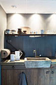 Rustikale Landhausküche mit Spüle aus Stein unterm Regal mit Tassen